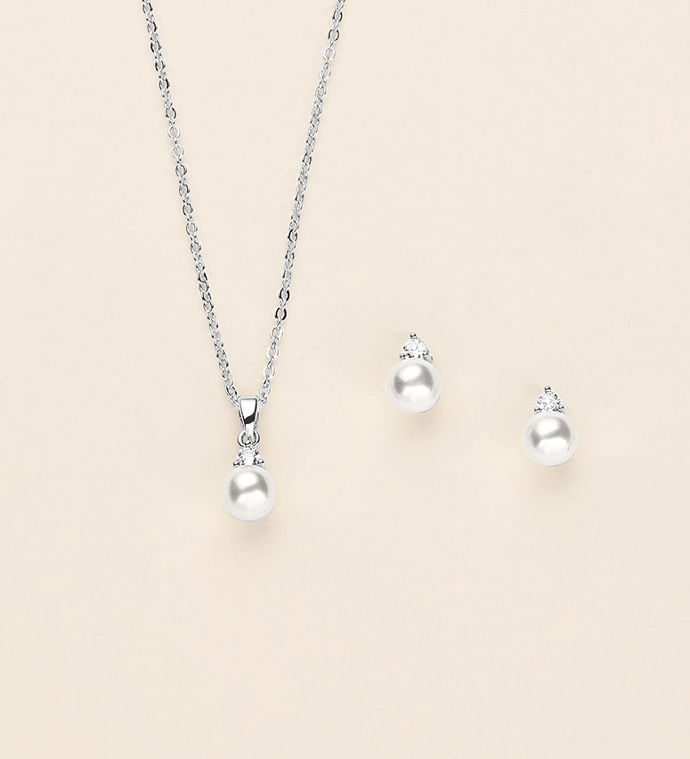 a necklace, earrings, and ring on a white background