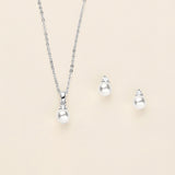 a necklace, earrings, and ring on a white background