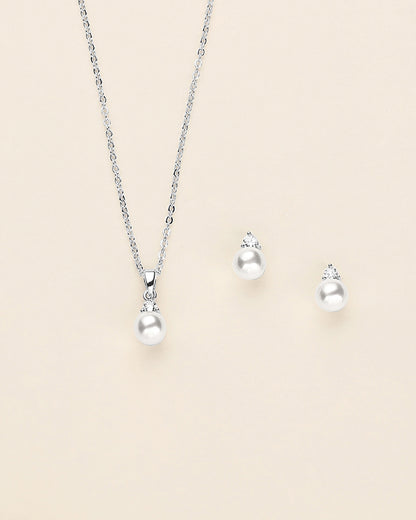 a necklace, earrings, and ring on a white background