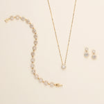 a necklace, earrings, and bracelet on a white surface
