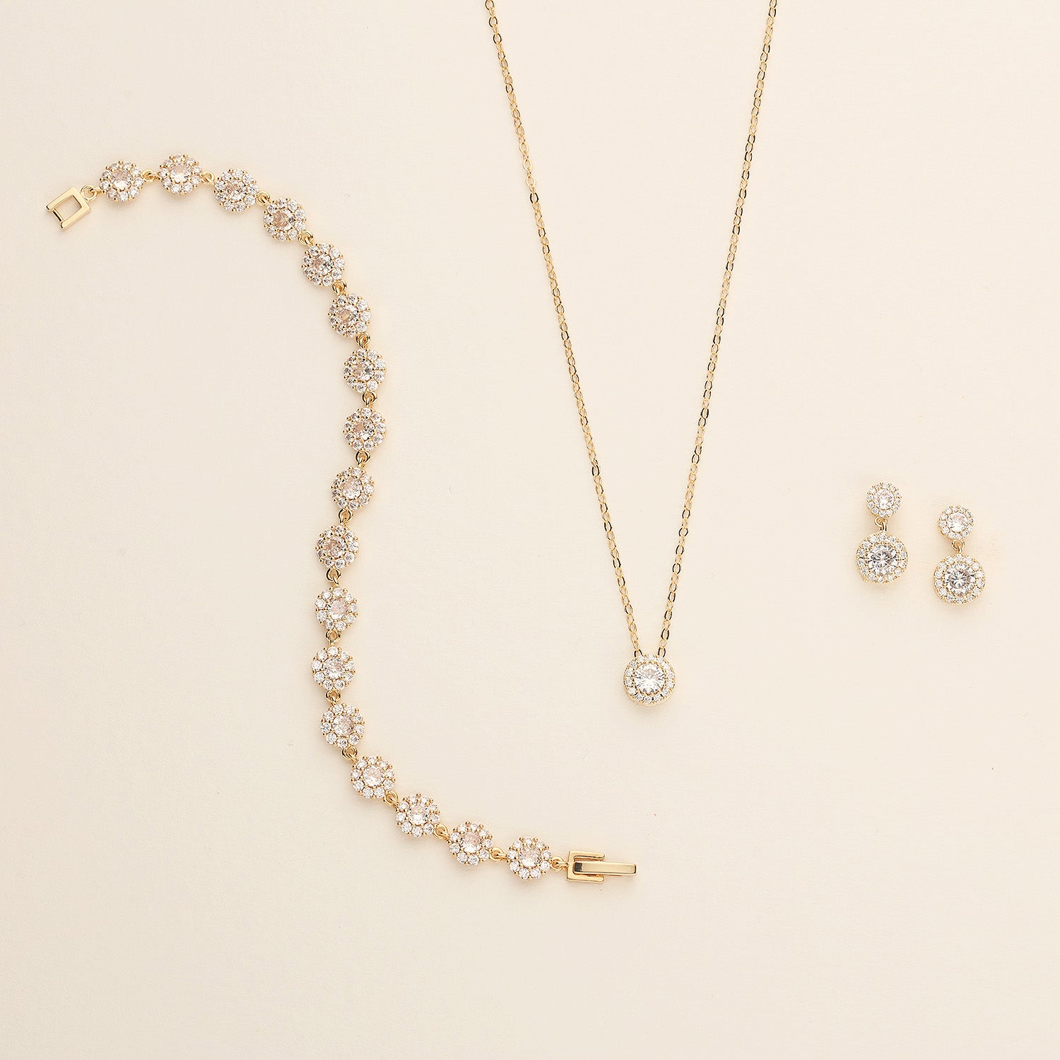 a necklace, earrings, and bracelet on a white surface