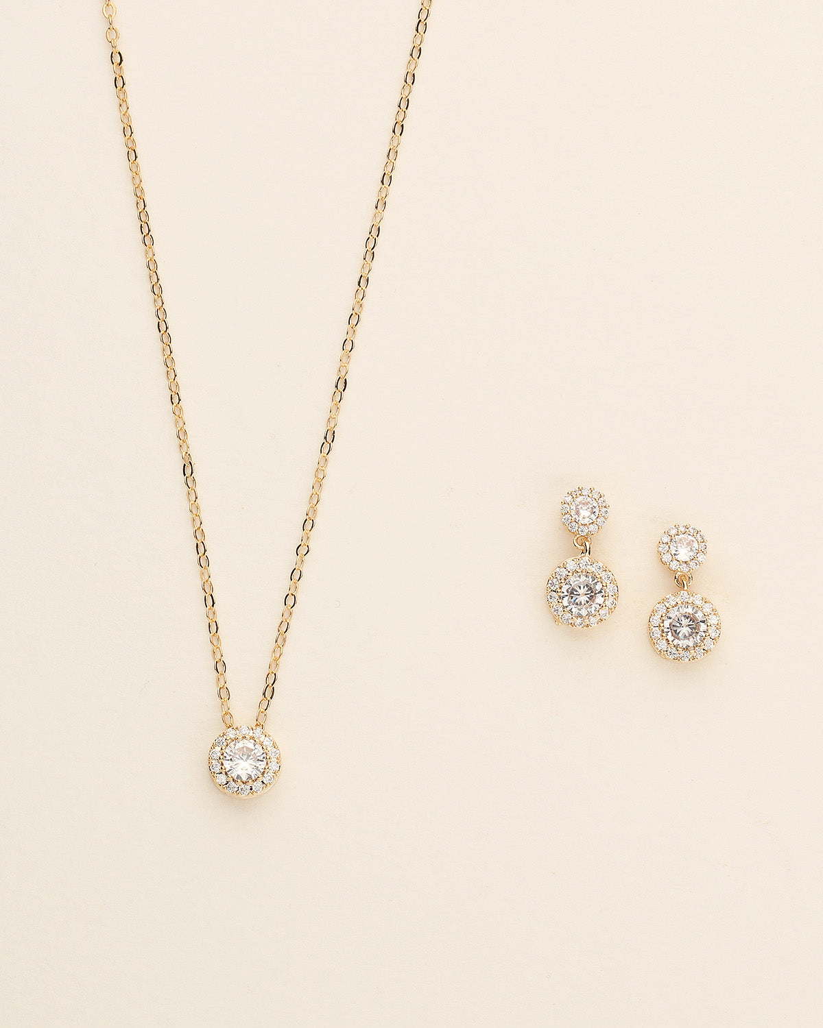 a necklace and earring set on a white surface