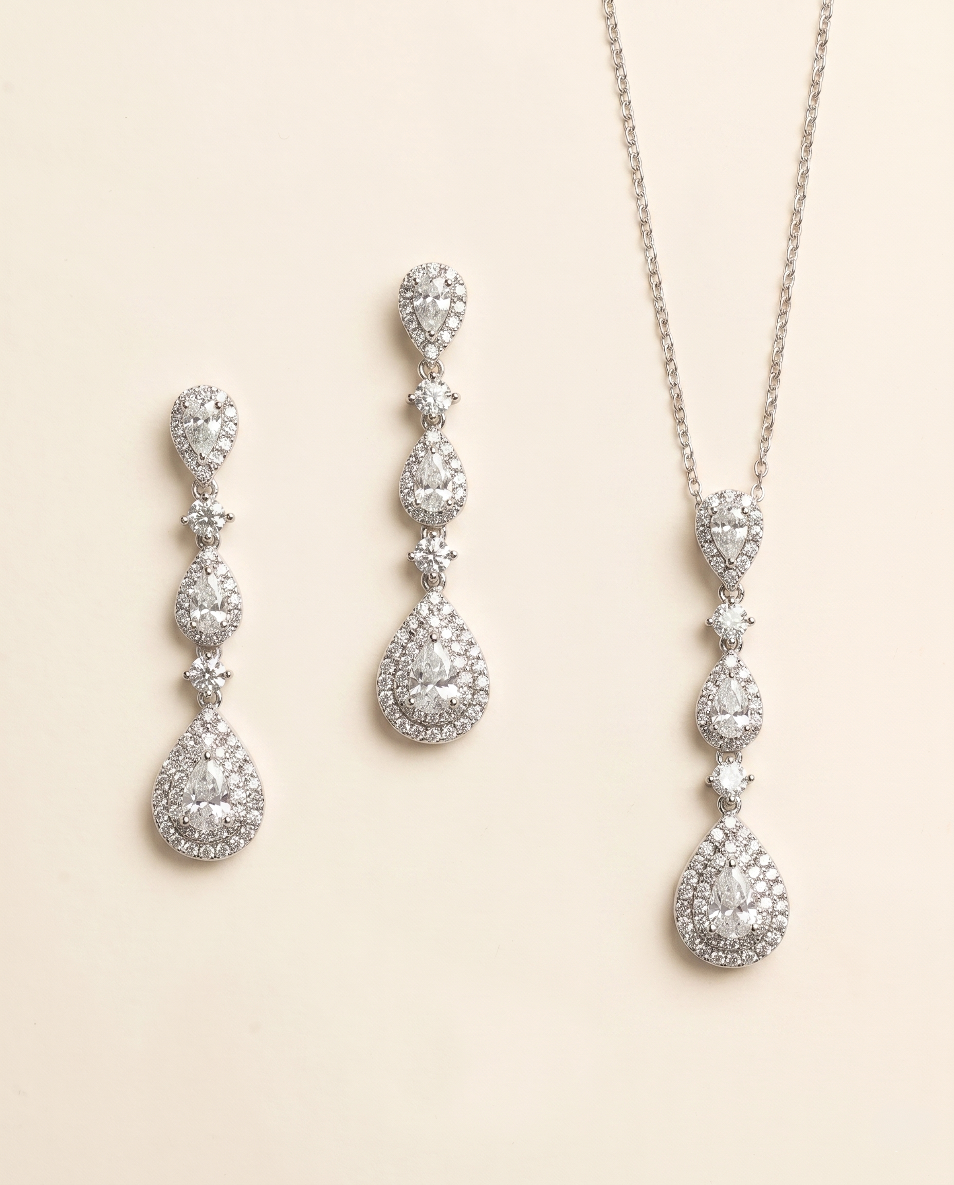 a set of elegant jewelry pieces, including earrings and a necklace, both adorned with numerous sparkling diamonds.