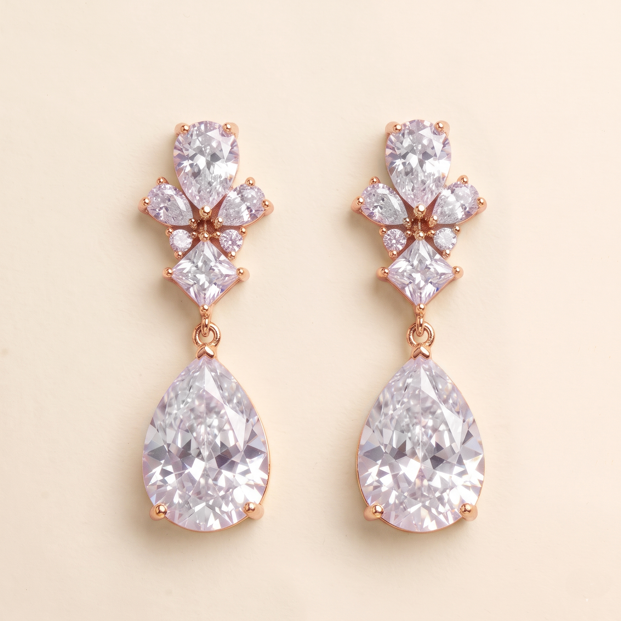 A pair of elegant earrings with large, clear gemstones set in a rose gold-colored metal.