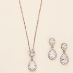 a necklace, bracelet, and earrings on a white surface