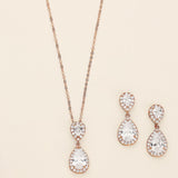 a necklace, bracelet, and earrings on a white surface