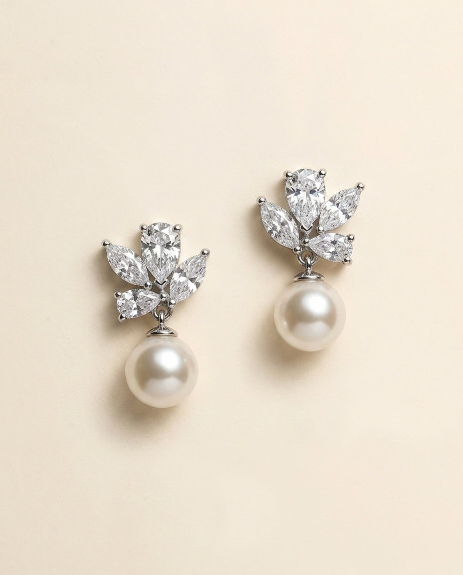 A pair of elegant earrings with a pearl and a cluster of diamonds as the main components.