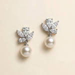 A pair of elegant earrings with a pearl and a cluster of diamonds as the main components.