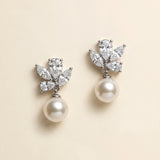 A pair of elegant earrings with a pearl and a cluster of diamonds as the main components.