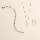a necklace, earrings, and bracelet on a white surface