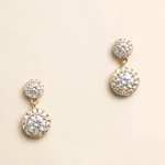 A pair of elegant gold earrings with large, clear gemstones set in a circular design.