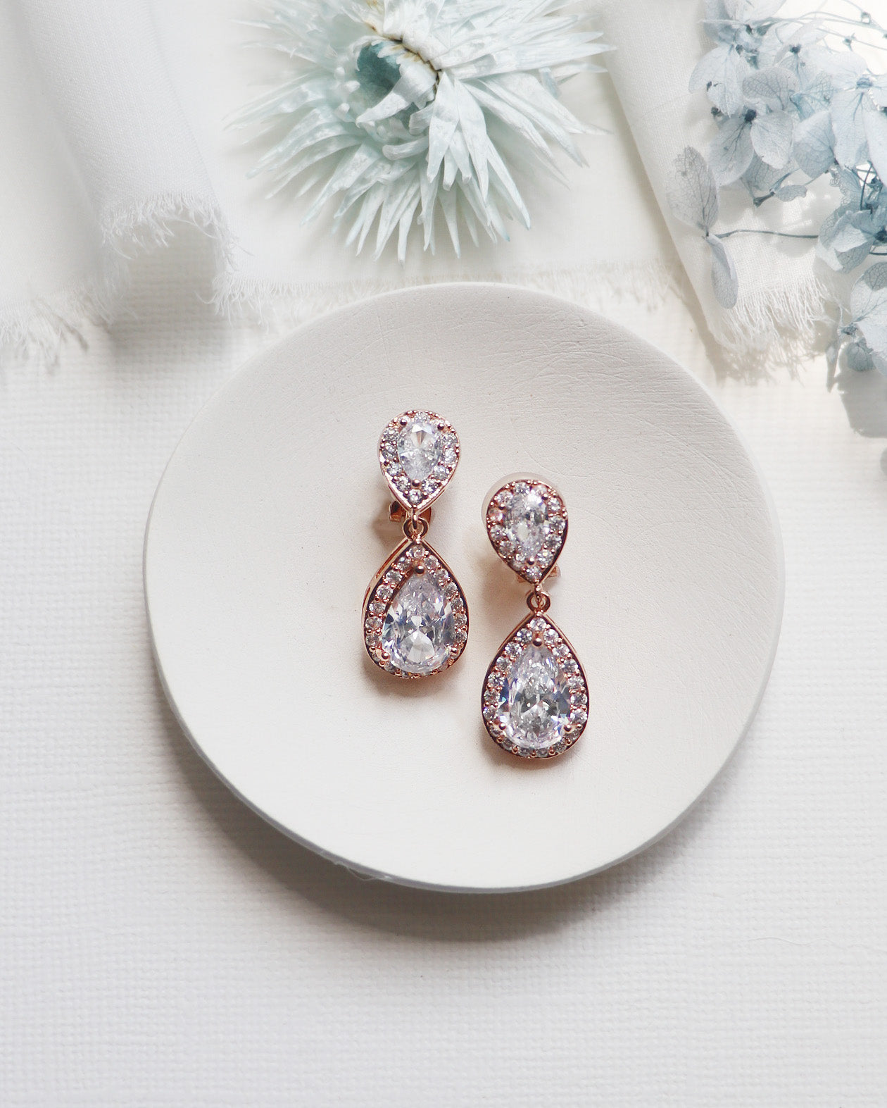 a pair of diamond earrings on a plate