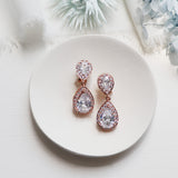 a pair of diamond earrings on a plate