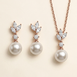 a necklace and earrings set with a combination of pearls and diamonds.