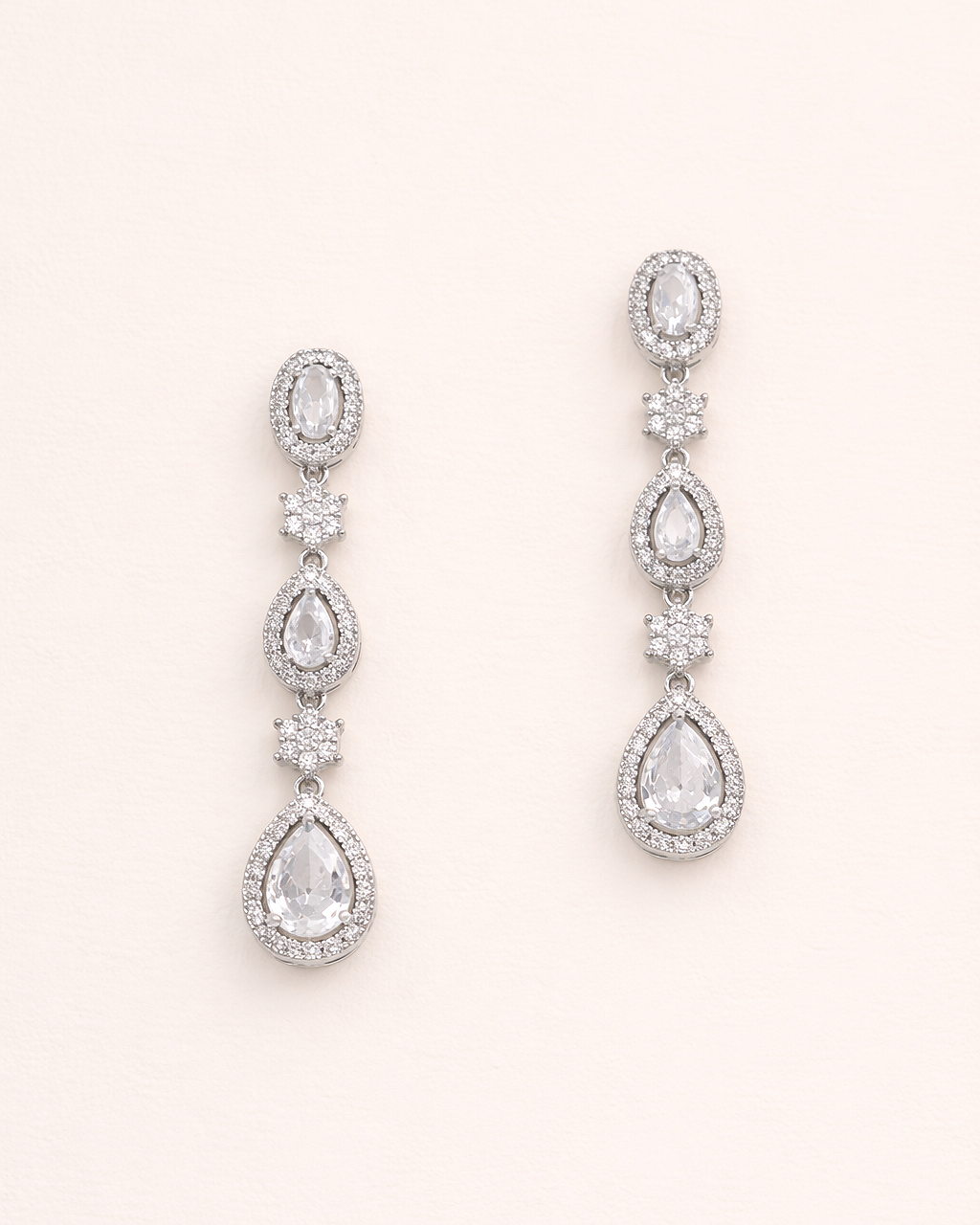 A pair of elegant earrings with multiple tiers of small, clear gemstones set in a metallic frame.