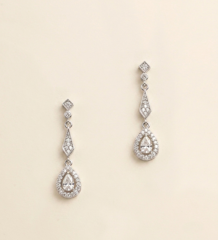 A pair of elegant earrings with a diamond-encrusted design, featuring a central pendant surrounded by smaller diamonds.