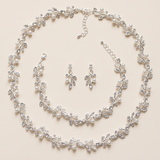 A delicate necklace and earrings set adorned with small, sparkling crystal leaves and pearls.