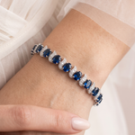 A close-up of a person's wrist wearing a bracelet with blue gemstones.
