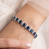 A close-up of a person's wrist wearing a bracelet with blue gemstones.
