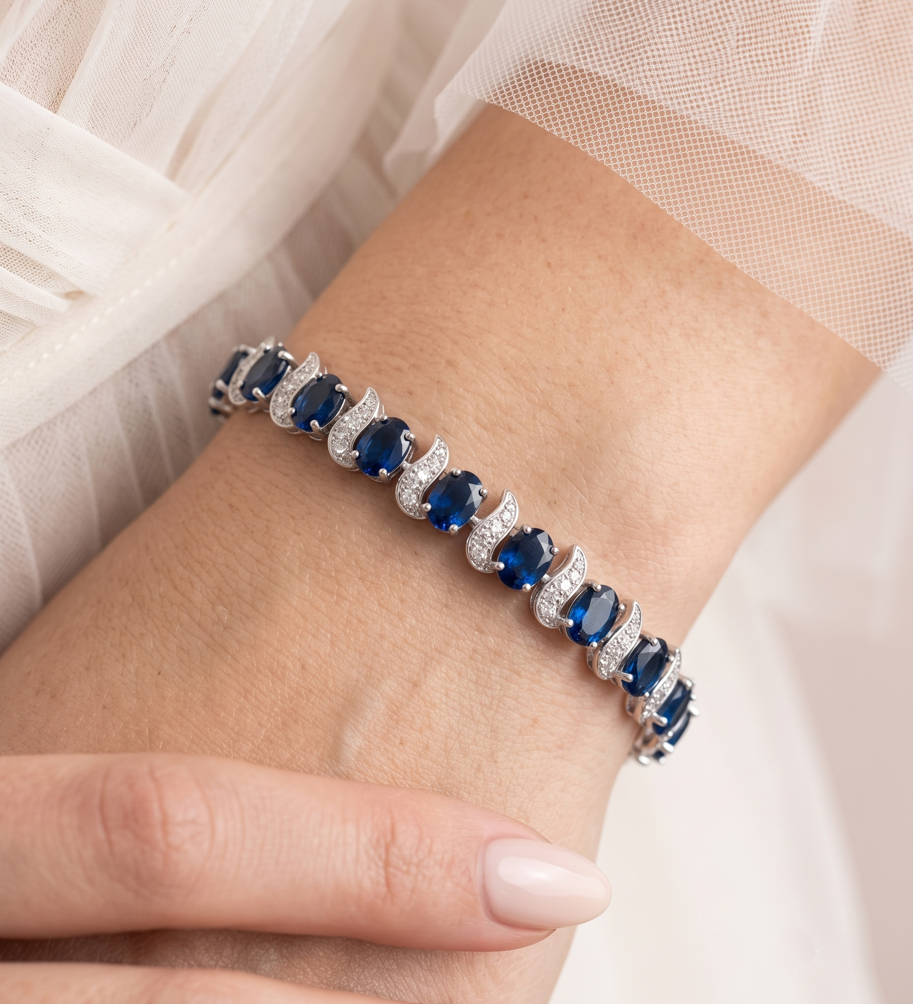 A close-up of a person's wrist wearing a bracelet with blue gemstones.