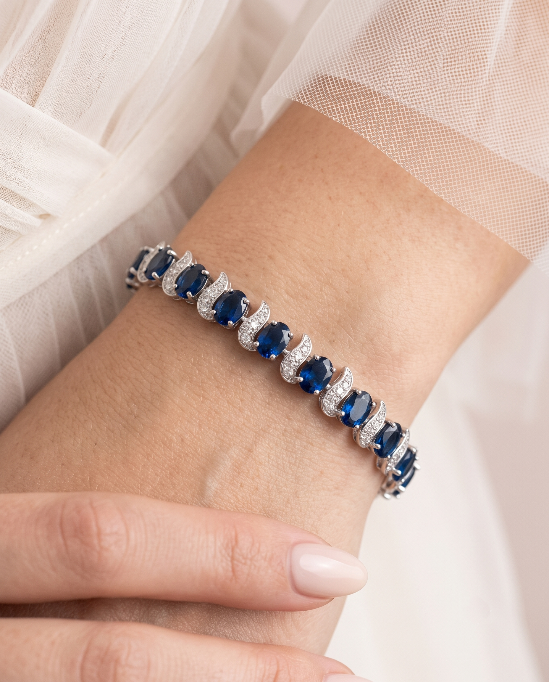 A close-up of a person's wrist wearing a bracelet with blue gemstones.