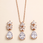A necklace with a pendant and earrings with a leaf-shaped design, all featuring large, clear gemstones.