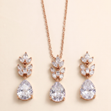 A necklace with a pendant and earrings with a leaf-shaped design, all featuring large, clear gemstones.