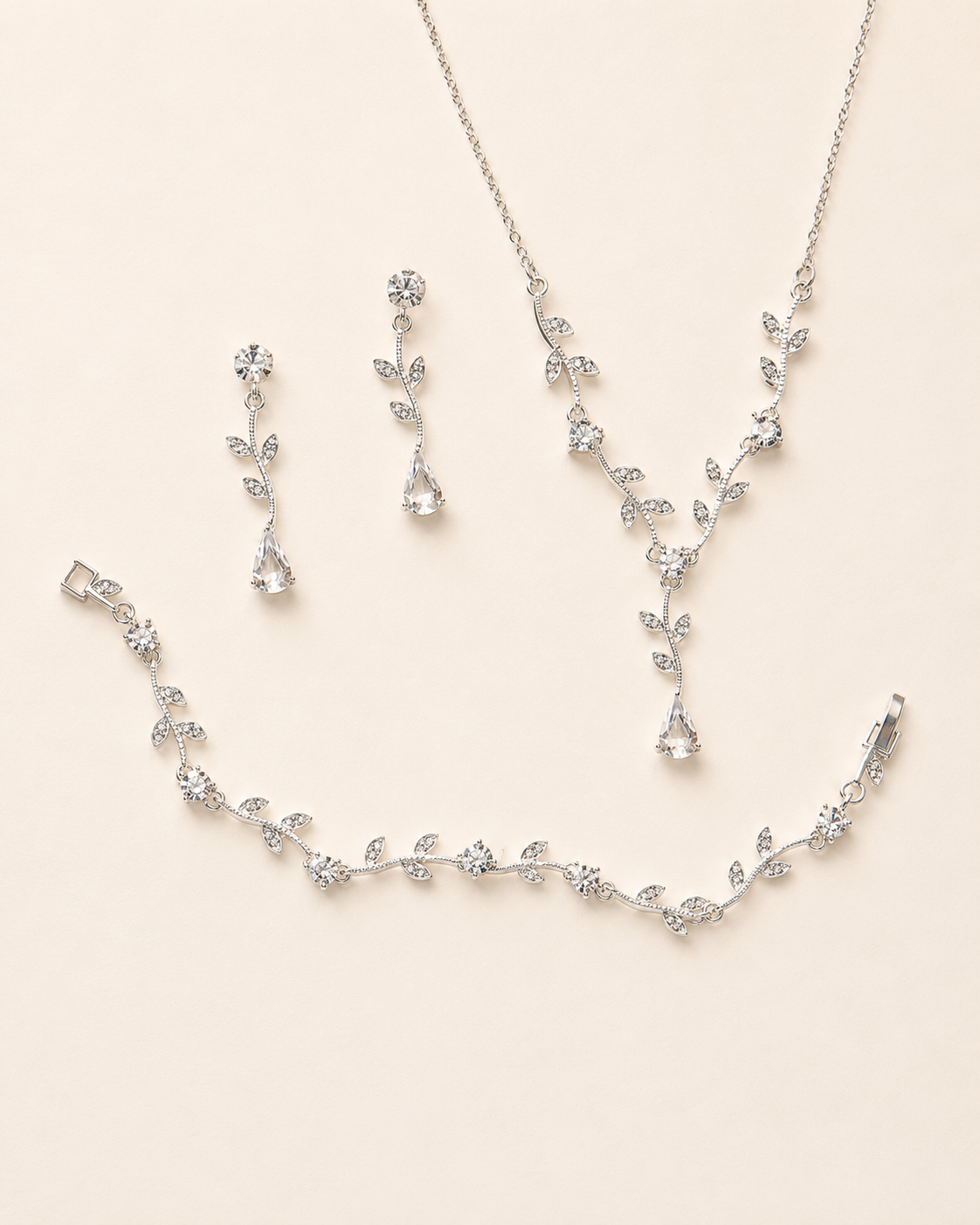 a delicate and elegant jewelry set consisting of a necklace, earrings, and a bracelet, all adorned with small, sparkling crystal elements.