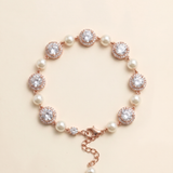 A bracelet with a clasp and a row of pearls and diamonds on a beige background.