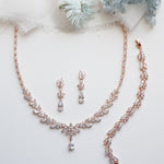 a necklace and earrings on a white surface