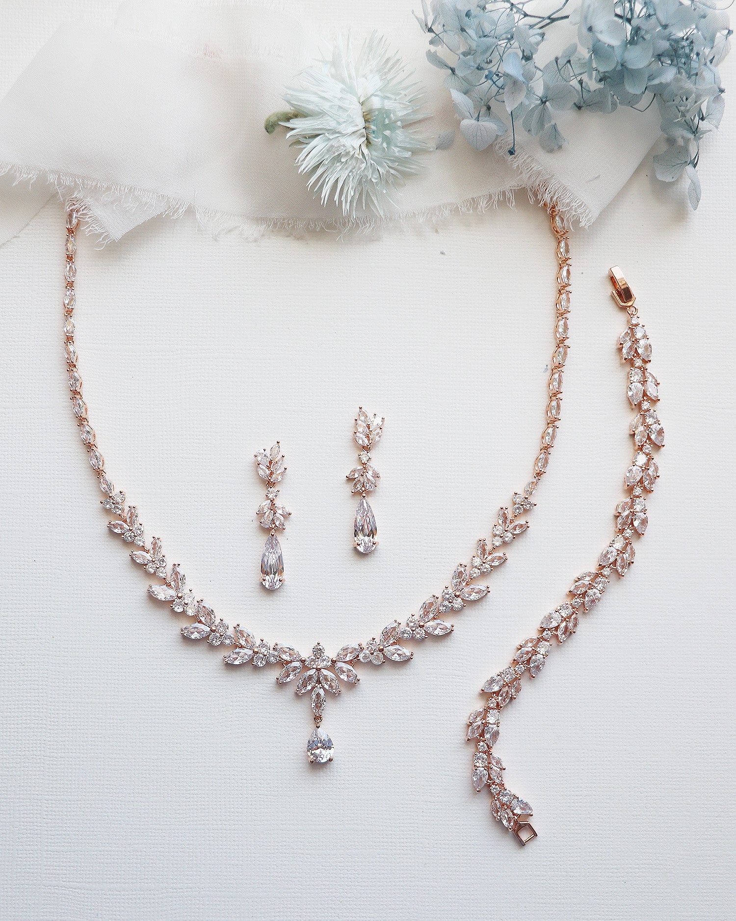 a necklace and earrings on a white surface