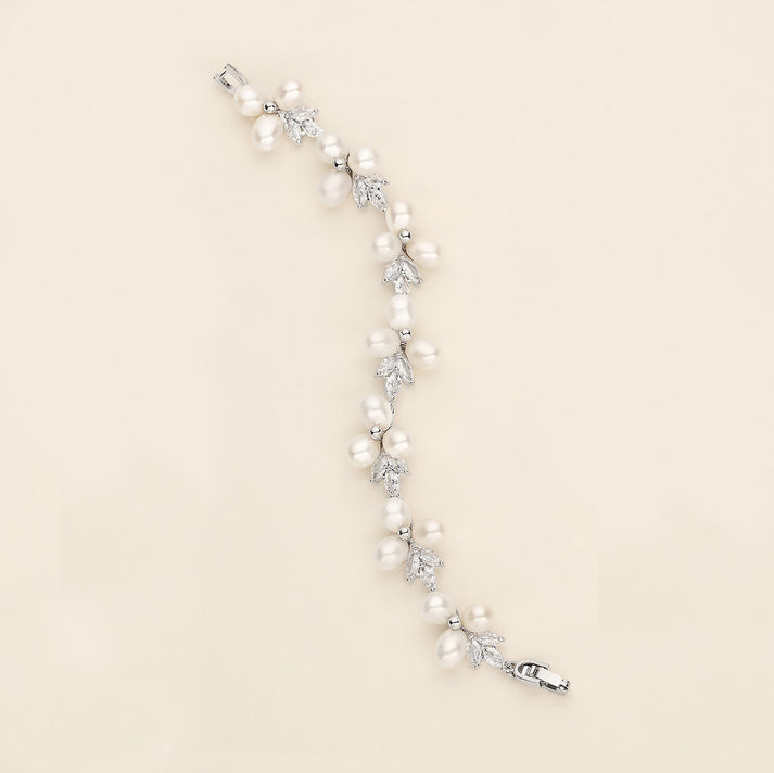 a white pearl and crystal bracelet on a white background