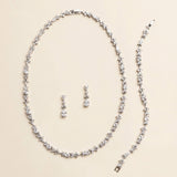 a necklace and earrings set made of sparkling diamonds arranged on a light-colored background.