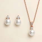 a necklace and earrings set against a light beige background.