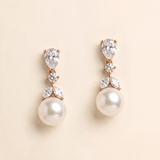 A pair of elegant pearl drop earrings with a delicate floral design and sparkling gemstones.