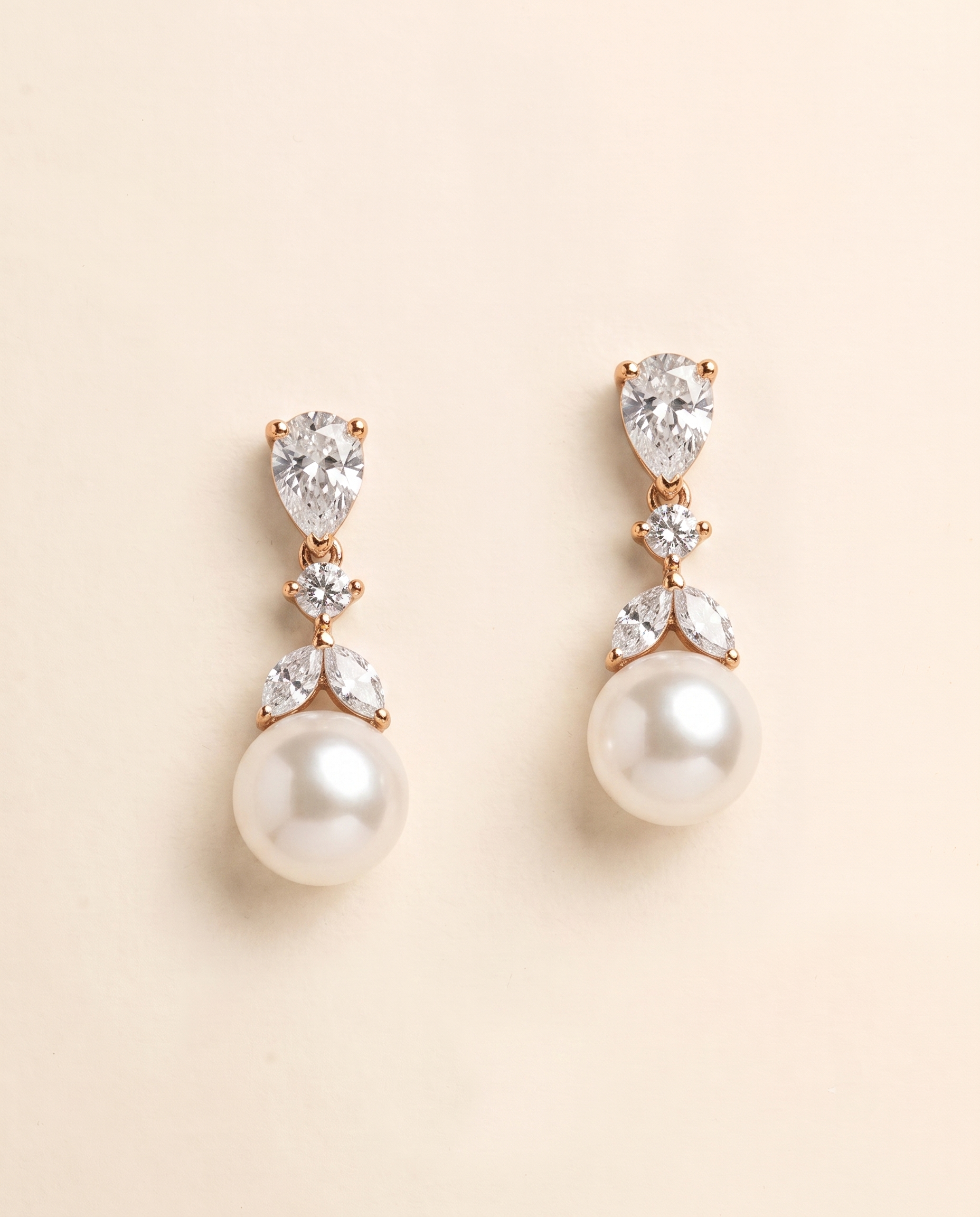A pair of elegant pearl drop earrings with a delicate floral design and sparkling gemstones.