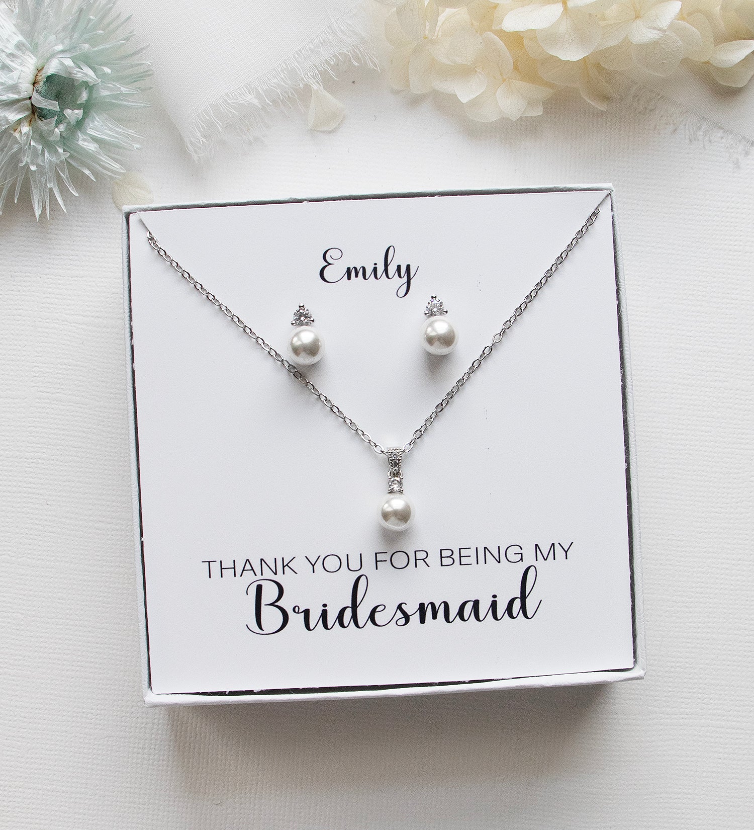 A necklace and earring set presented in a white box, with a personalized message on the box.
