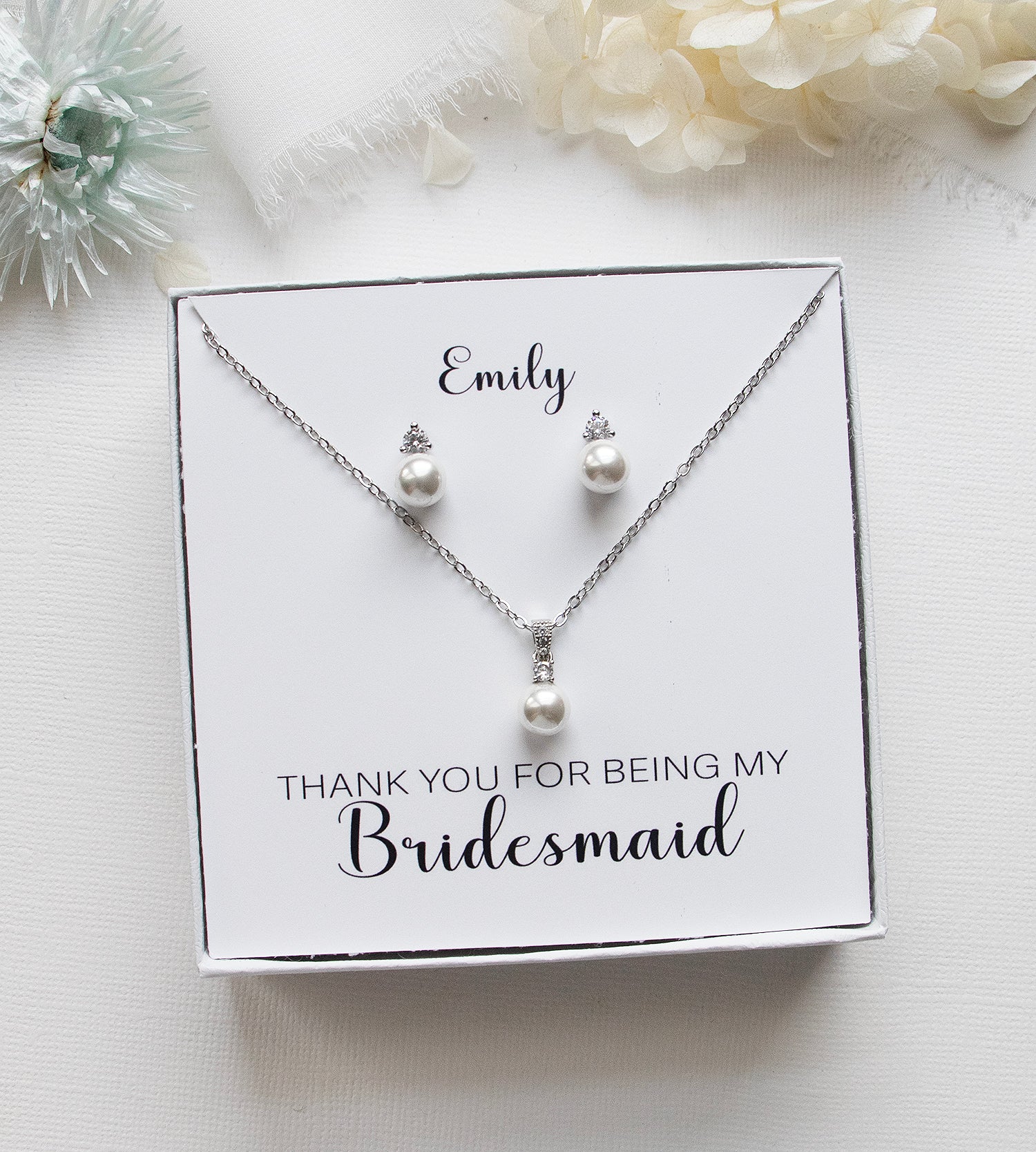 A necklace and earring set presented in a white box, with a personalized message on the box.