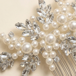 a close-up view of a decorative hair accessory, which appears to be a hair comb or hairbrush adorned with numerous crystal and pearl embellishments.