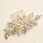 A decorative hair accessory with a combination of pearls, crystals, and leaves.