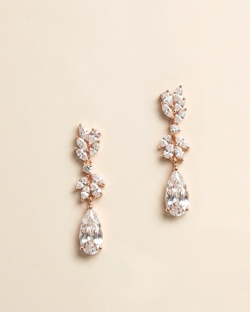 A pair of elegant gold earrings with large, clear gemstones hanging from the bottom.