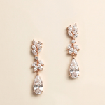 A pair of elegant gold earrings with large, clear gemstones hanging from the bottom.