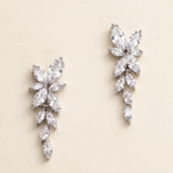 A pair of elegant earrings with large, clear gemstones arranged in a floral design.