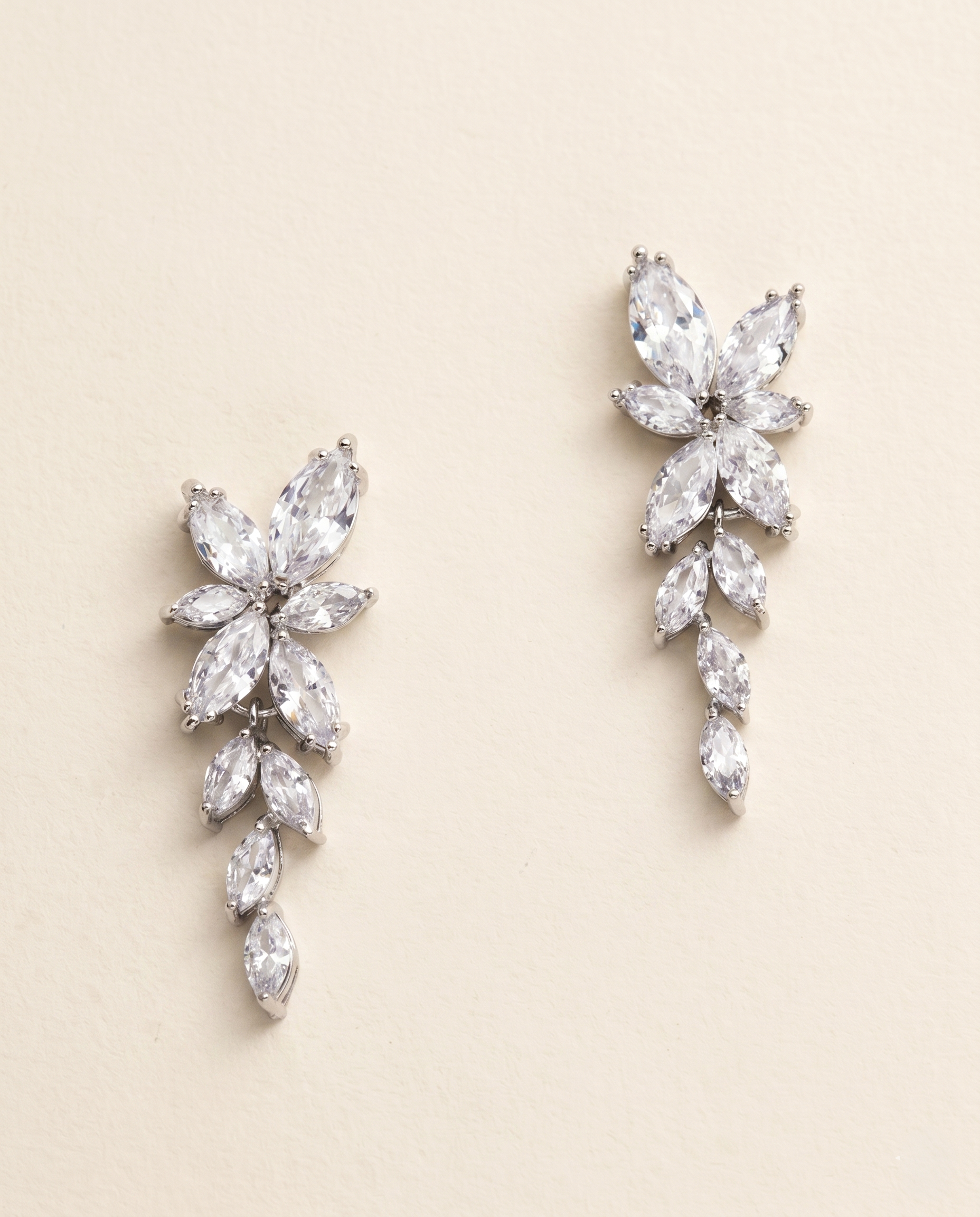 A pair of elegant earrings with large, clear gemstones arranged in a floral design.