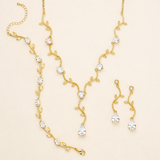 a set of gold jewelry pieces, including a necklace, earrings, and a bracelet, all adorned with small, clear gemstones.