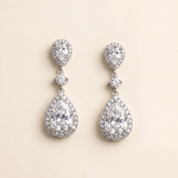 A pair of elegant earrings with large, clear gemstones set in a halo-like design.