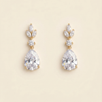 A pair of elegant gold earrings with large, clear gemstones.