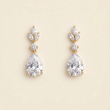 A pair of elegant gold earrings with large, clear gemstones.