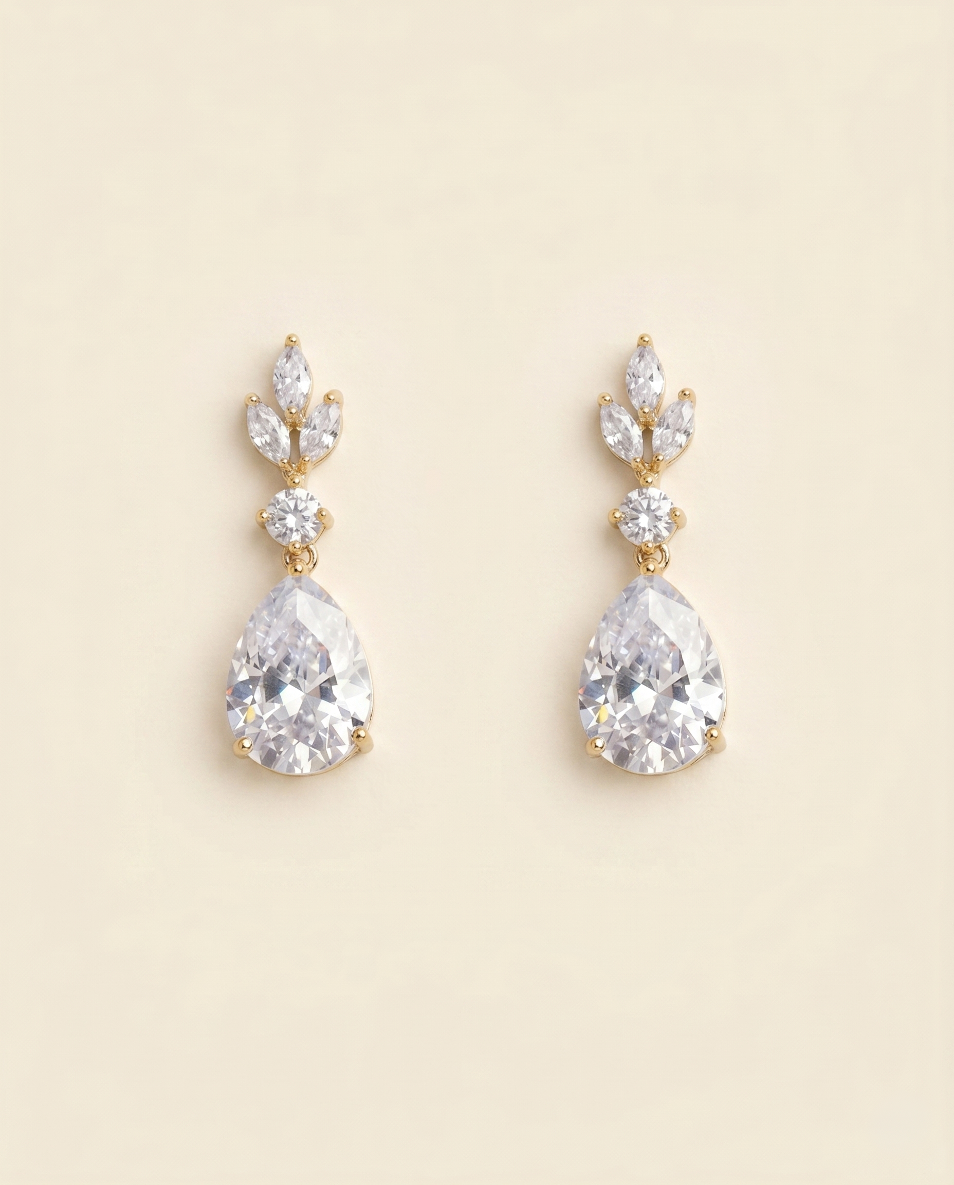 A pair of elegant gold earrings with large, clear gemstones.