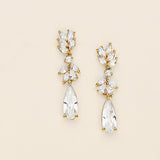 a pair of gold tone earrings with clear stones